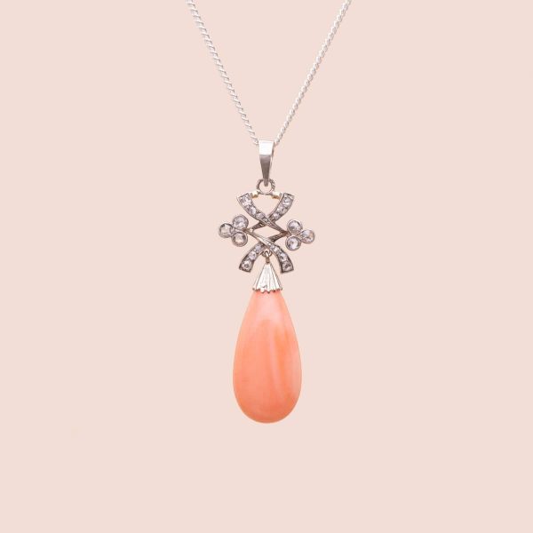 Pendentif vintage orné d'une goutte de corail rose retenu par un motif de noeud géométrique en or