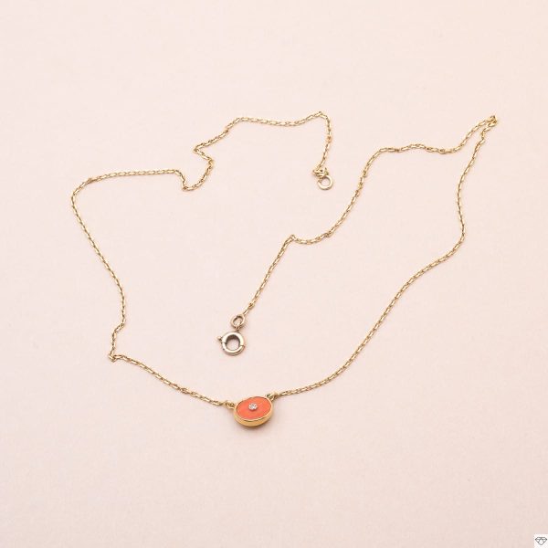 Collier à chaine fine orné d'un motif fixe de corail sertis au centre d'un diamant