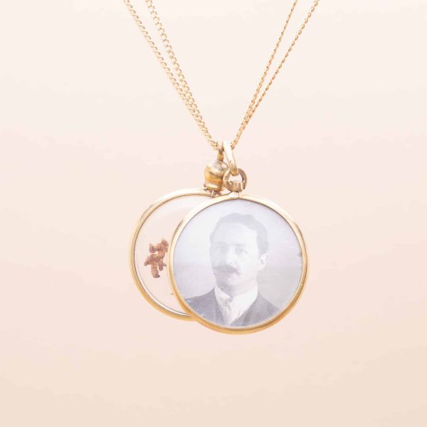 Deux pendentifs ronds anciens transparent l'un contenant des fleurs l'autre deux photos