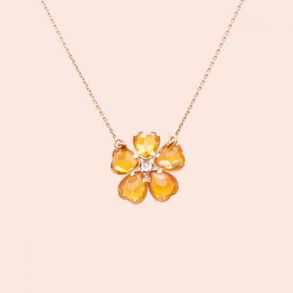 Zoom sur le pendentif du collier en forme de petite fleur jaune